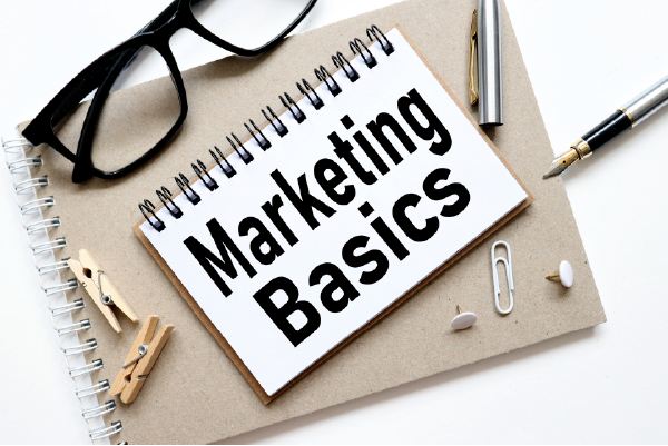 A notebook, a pen and other tools you need to start writing marketing basics. 