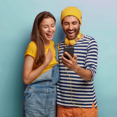 Young couple dressed in yellow smiling amazedly and satisfied with the results after purchasing Instagram followers from 1394TA.
