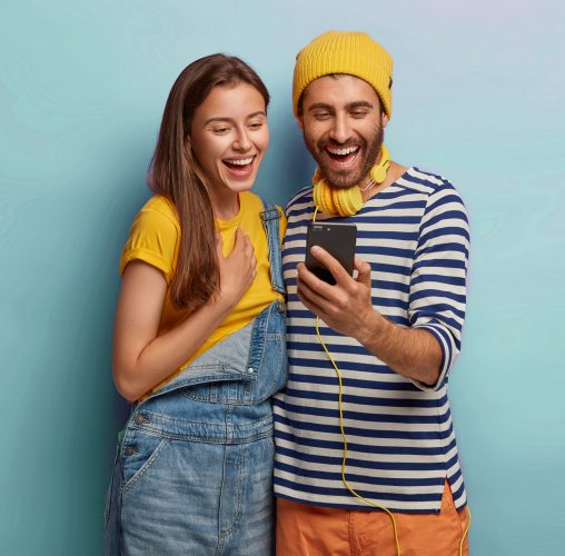Young couple dressed in yellow smiling amazedly and satisfied with the results after purchasing Instagram followers from 1394TA.